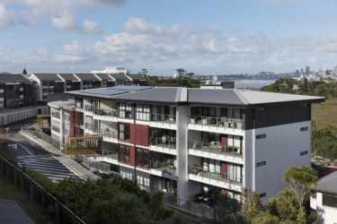 Northbridge retirement village on a sunny day, Auckland harbour is visible in the background